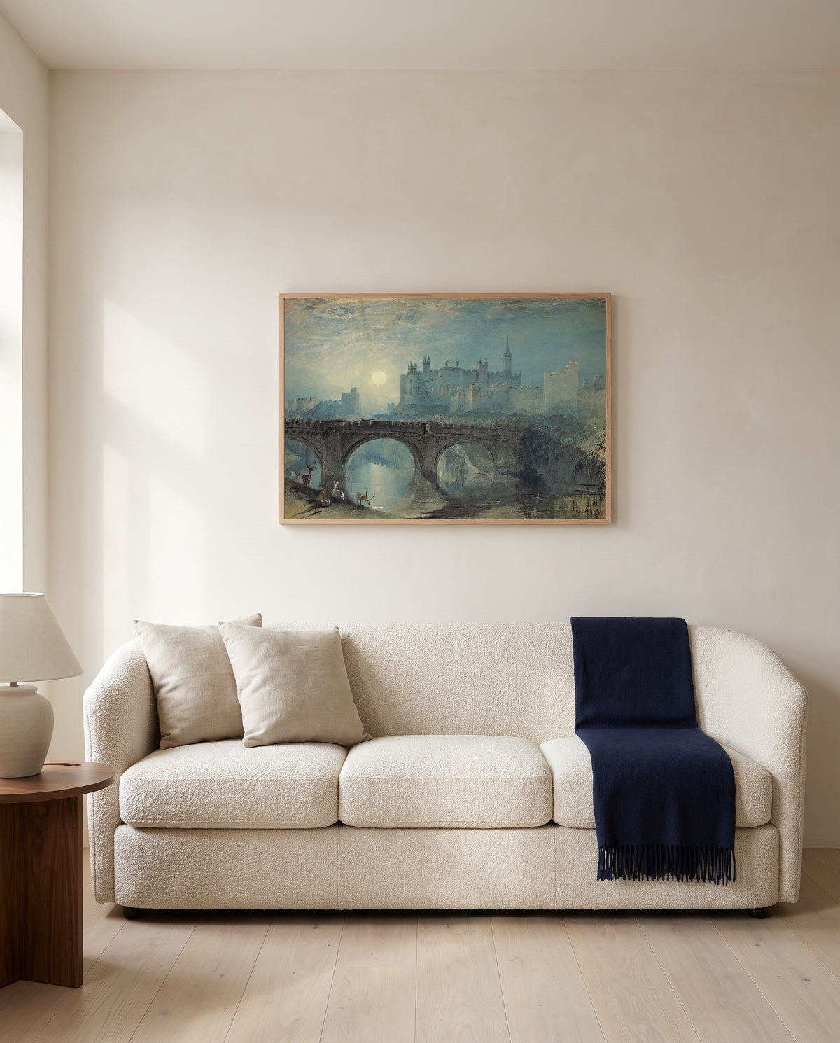 Alnwick Castle by J. M. W. Turner framed in natural oak above a cream sofa in a warm living room