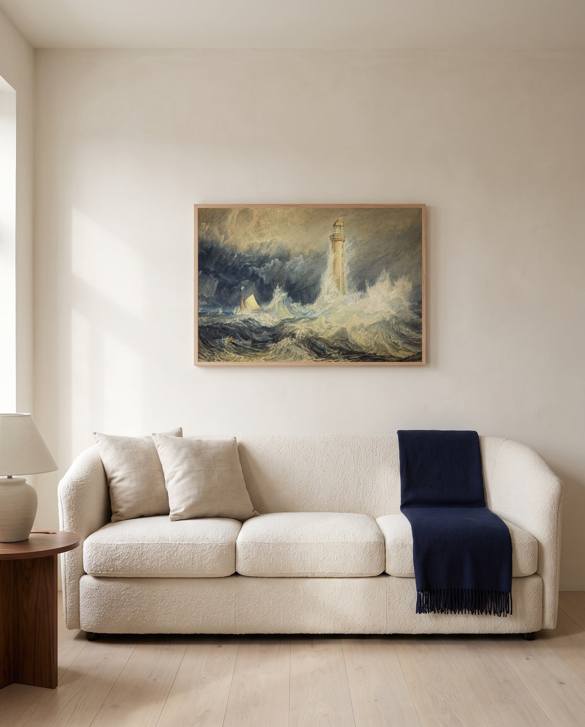 Bell Rock Lighthouse by J. M. W. Turner framed in natural oak above a cream sofa in a warm living room