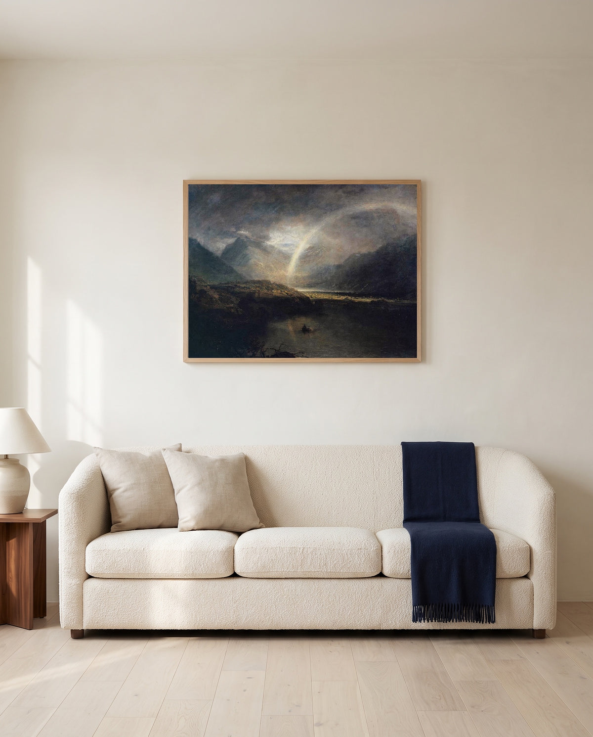 Buttermere Lake by J. M. W. Turner framed in natural oak above a cream sofa in a warm living room