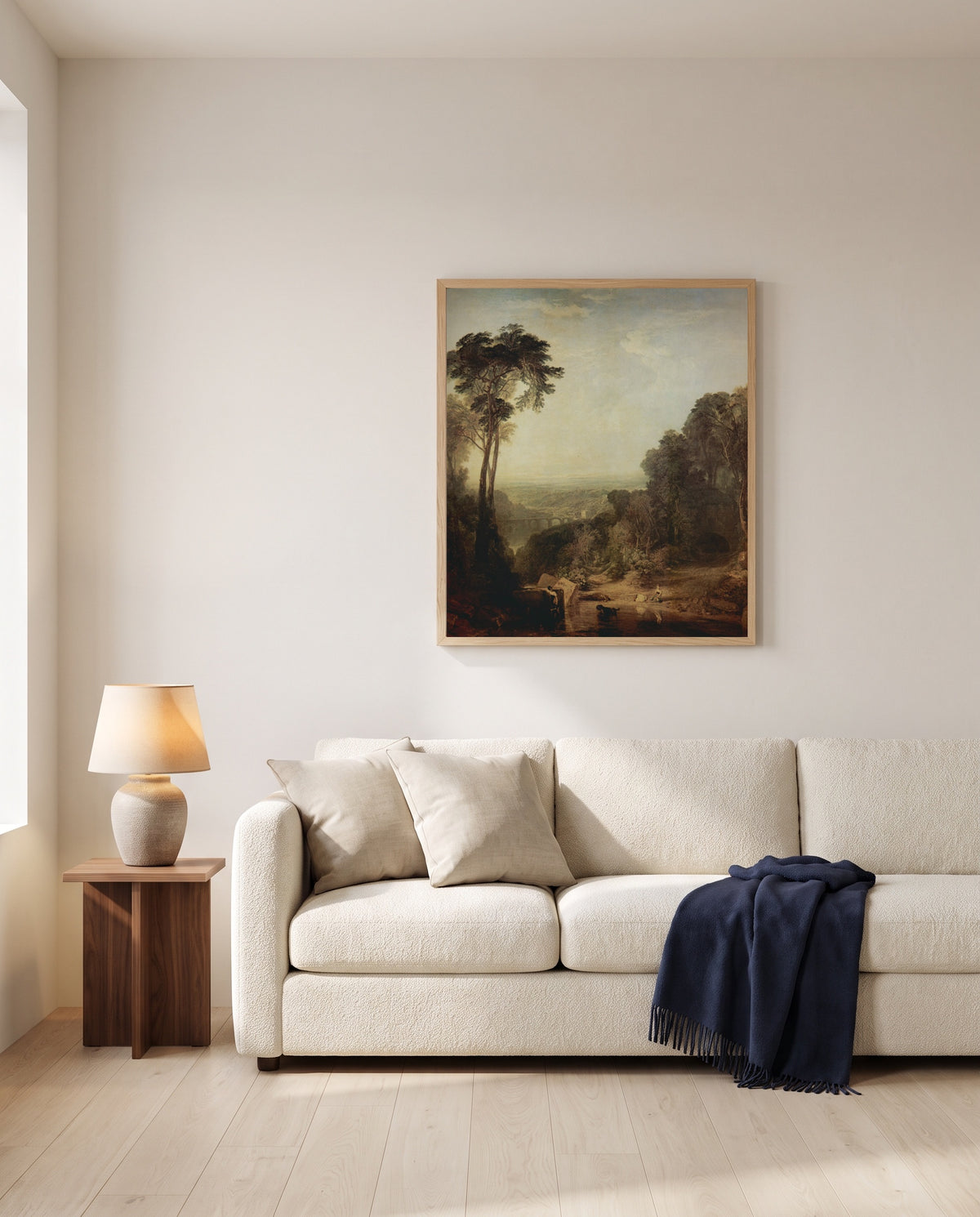 Crossing the Brook by J. M. W. Turner framed in natural oak above a cream sofa in a warm living room