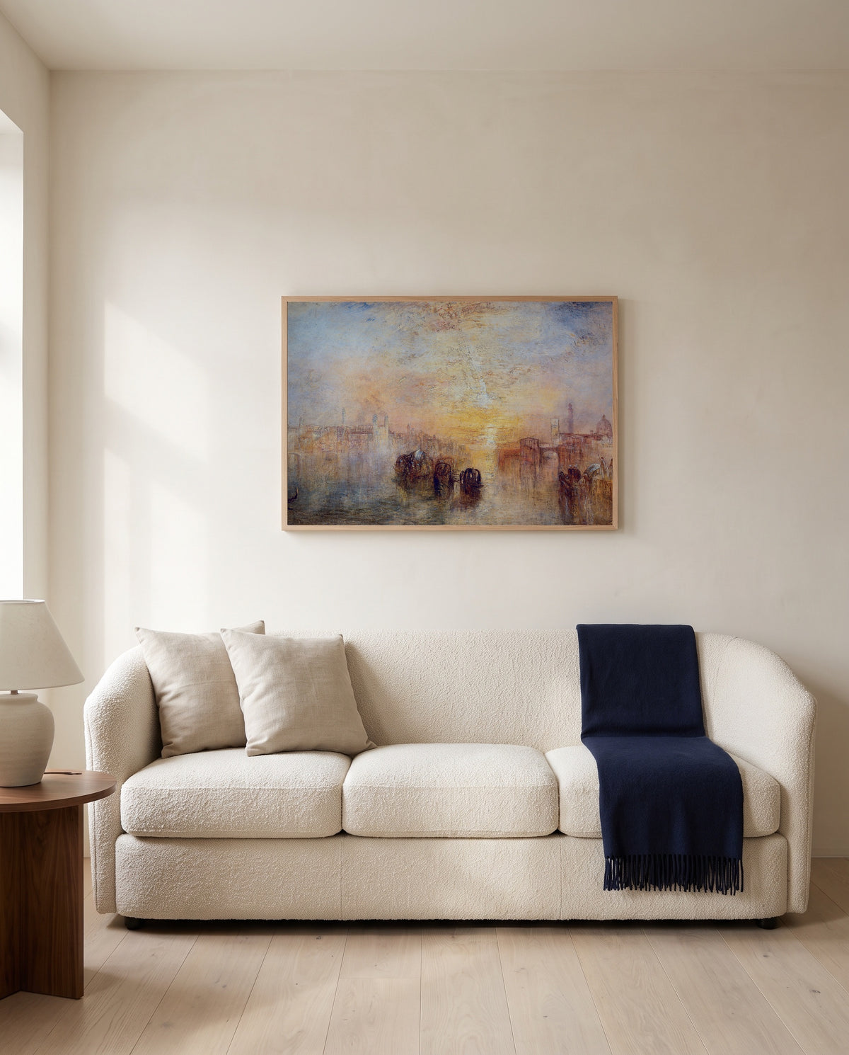 Going to the Ball by J. M. W. Turner framed in natural oak above a cream sofa in a warm living room