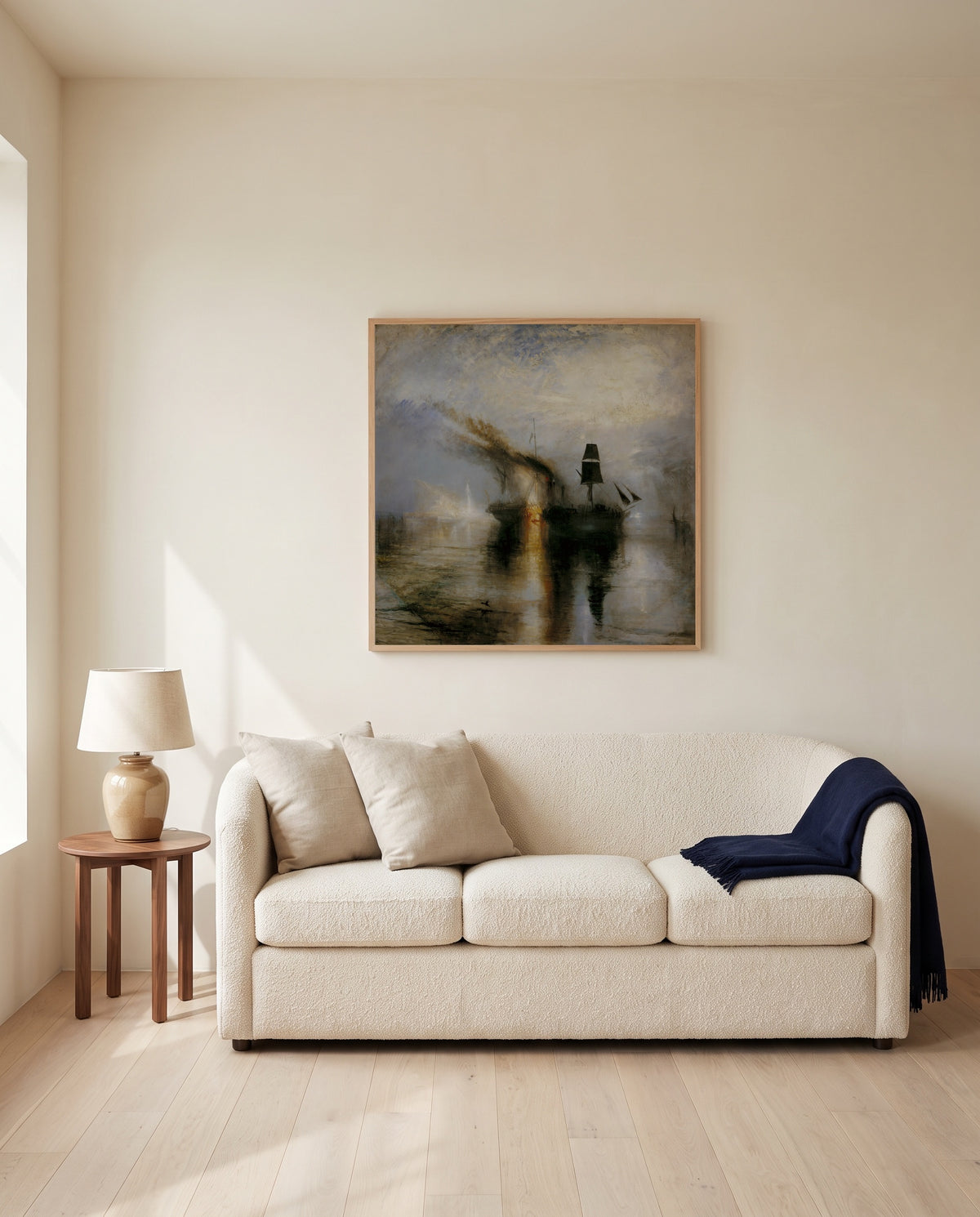Peace – Burial at Sea by J. M. W. Turner framed in natural oak above a cream sofa in a warm living room