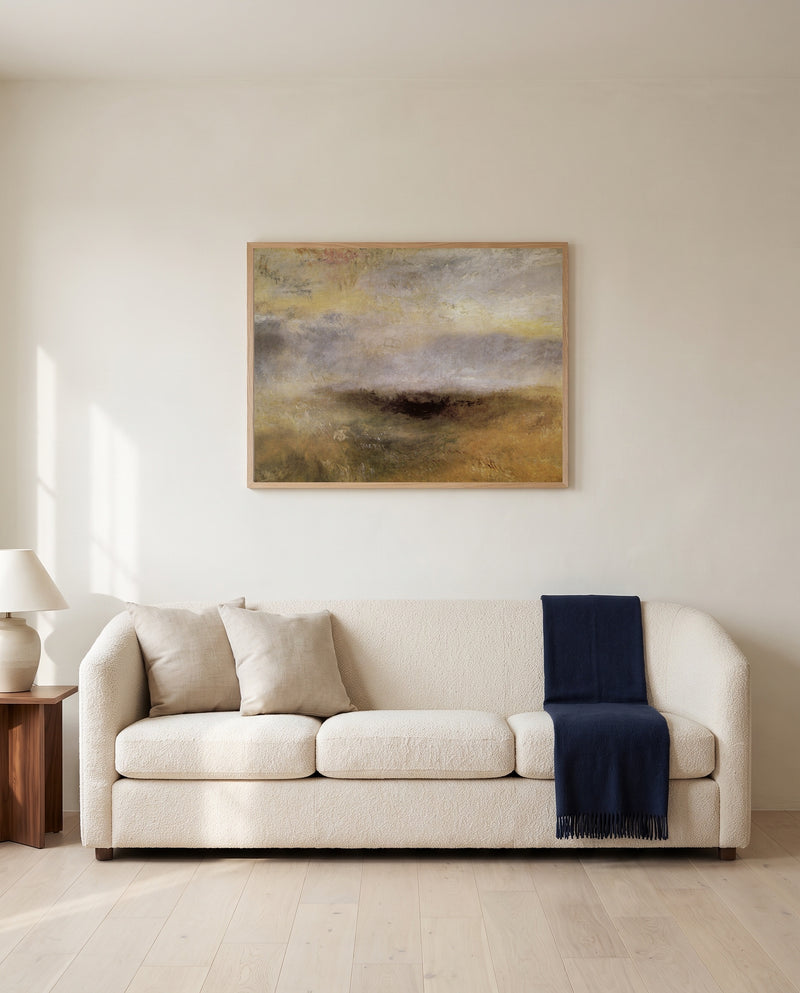 Storm Coming On by J. M. W. Turner framed in natural oak above a cream sofa in a warm living room