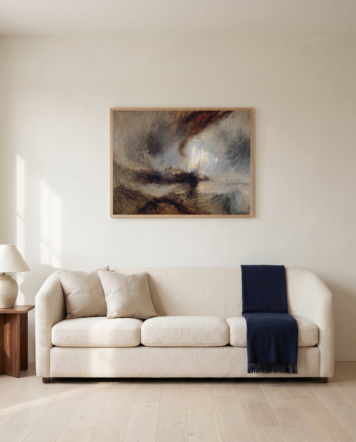 Snow Storm: Steam-Boat by J. M. W. Turner framed in natural oak above a cream sofa in a warm living room
