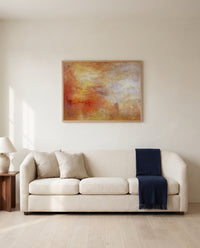 Sun Setting over a Lake by J. M. W. Turner framed in natural oak above a cream sofa in a warm living room