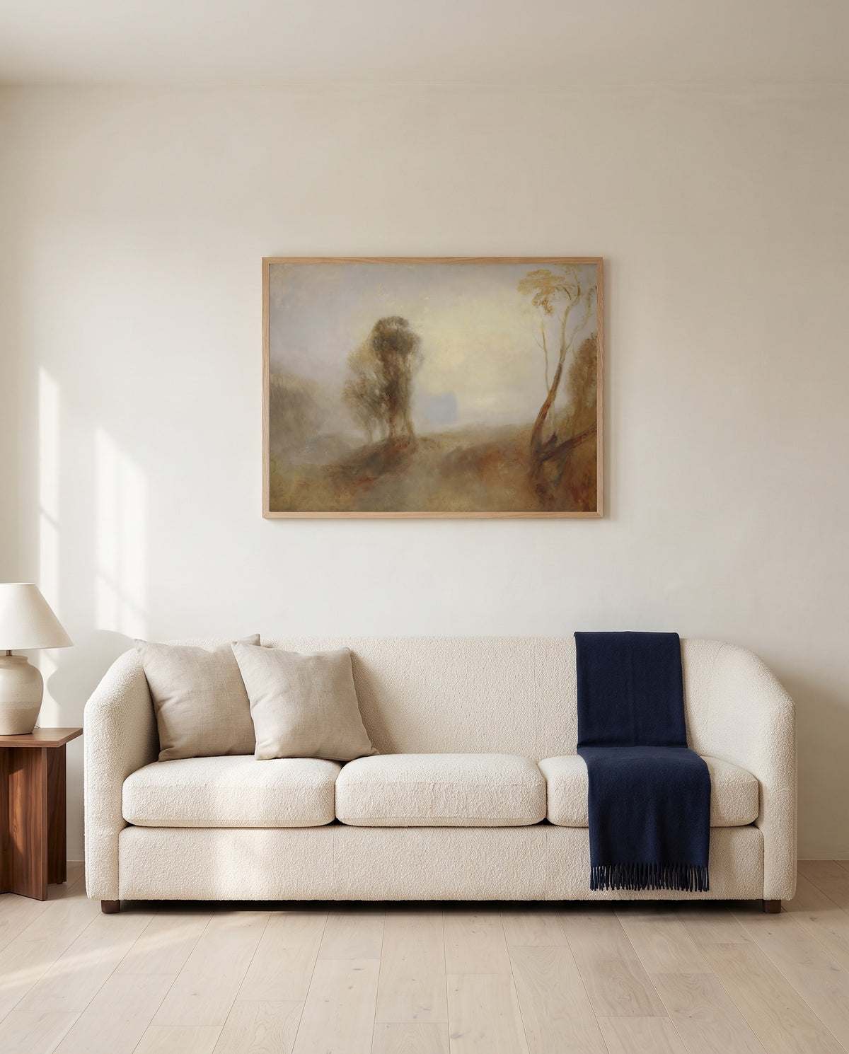 Castle on a Bay: Solitude by J. M. W. Turner framed in natural oak above a cream sofa in a warm living room