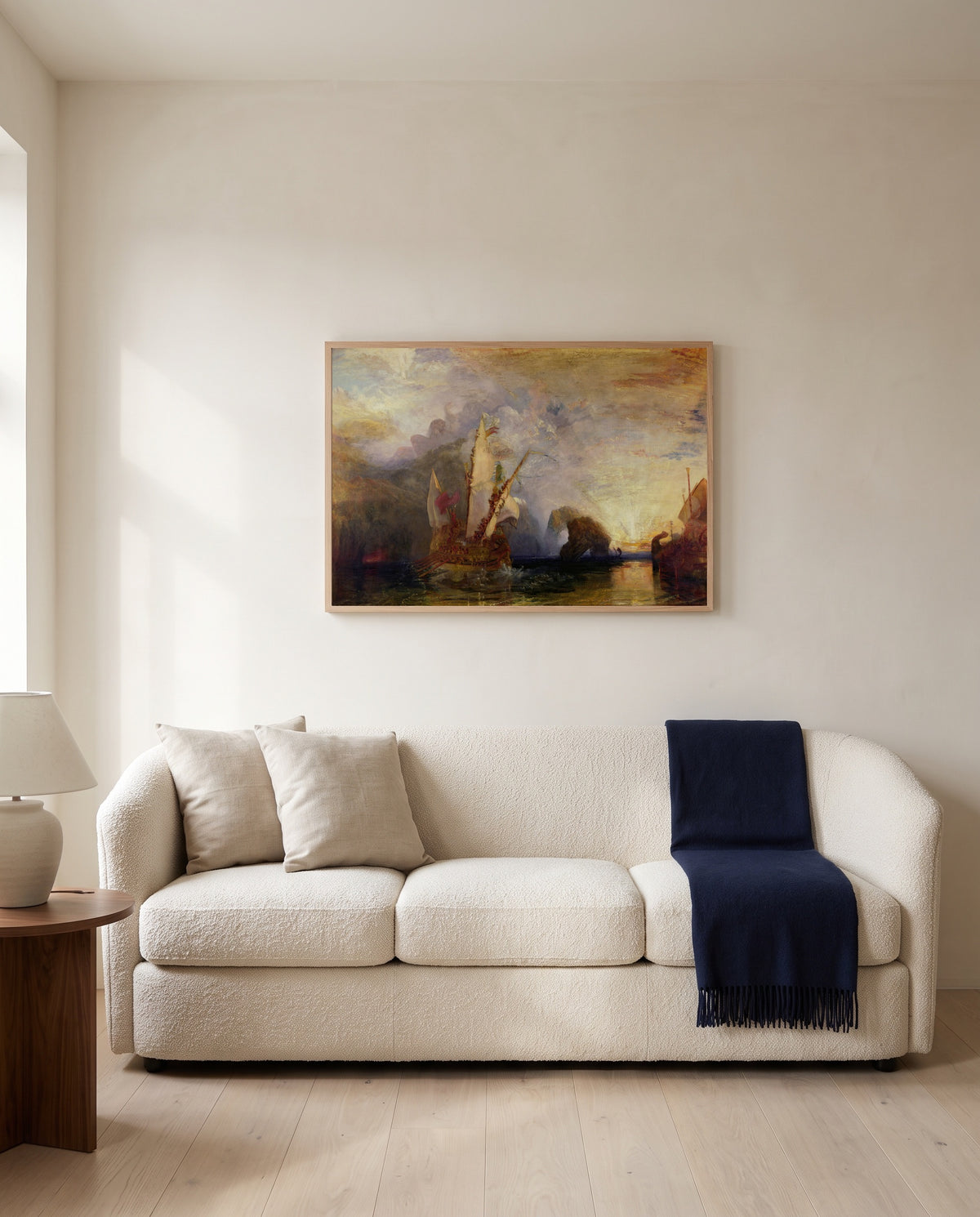 Ulysses Deriding Polyphemus by J. M. W. Turner framed in natural oak above a cream sofa in a warm living room
