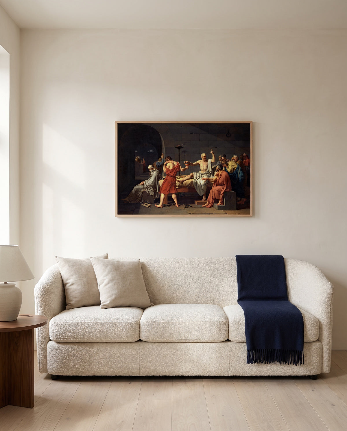 The Death of Socrates by Jacques-Louis David framed in natural oak above a cream sofa in a warm living room