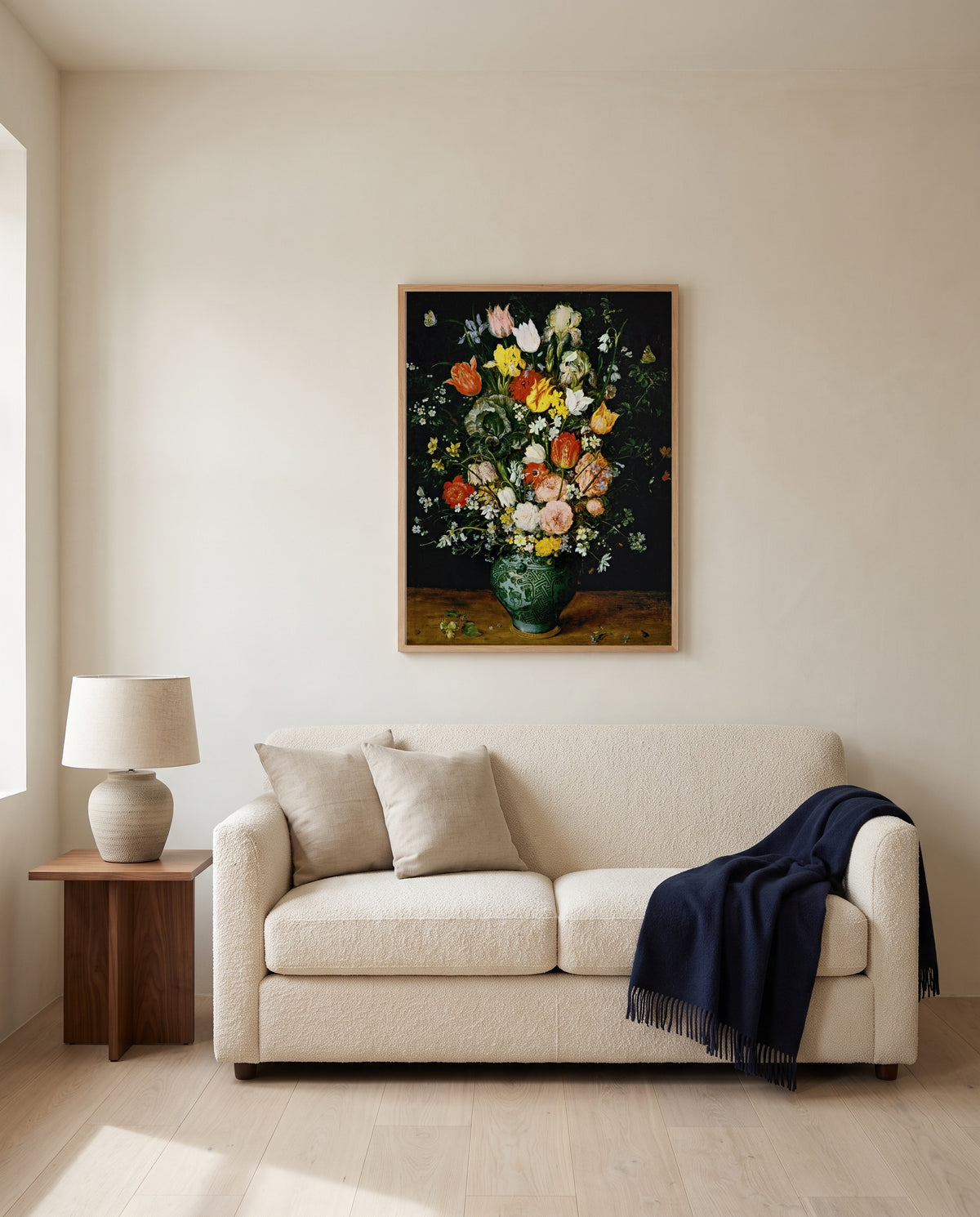 Flowers in a Blue Vase by Jan Brueghel the Elder framed in natural oak above a cream sofa in a warm living room
