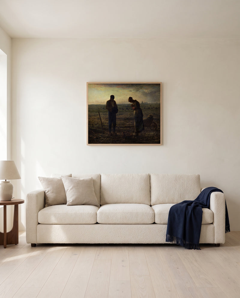 The Angelus by Jean-François Millet framed in natural oak above a cream sofa in a warm living room
