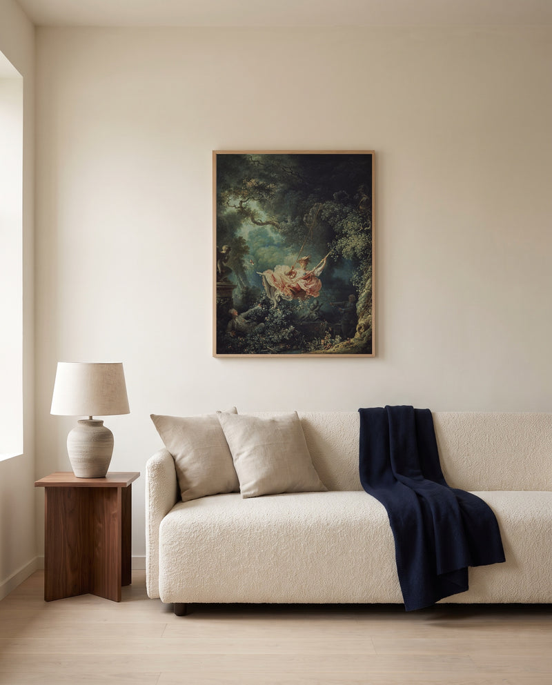 The Swing by Jean-Honoré Fragonard framed in natural oak above a cream sofa in a warm living room
