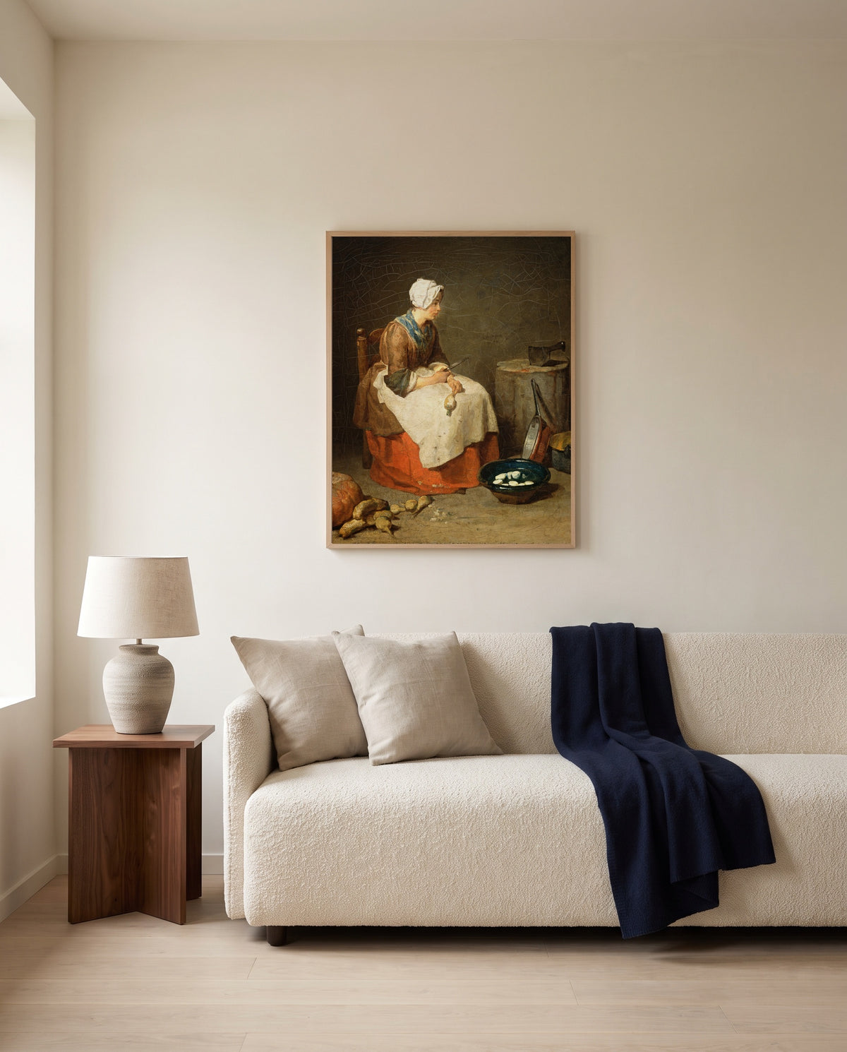 The Kitchen Maid by Jean Siméon Chardin framed in natural oak above a cream sofa in a warm living room