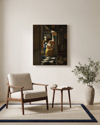 The Love Letter by Johannes Vermeer as a stretched canvas above a linen lounge chair in a reading corner