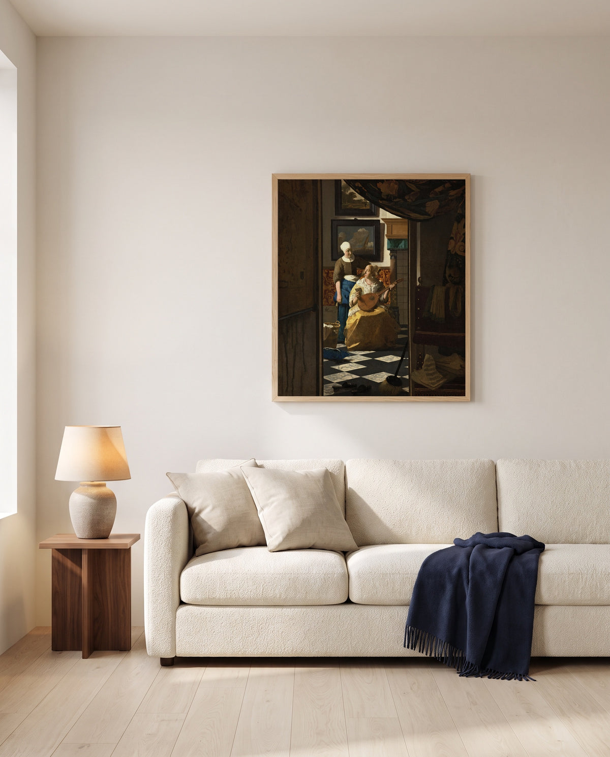 The Love Letter by Johannes Vermeer framed in natural oak above a cream sofa in a warm living room