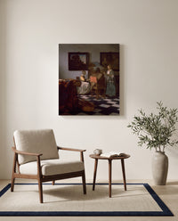 The Concert by Johannes Vermeer as a stretched canvas above a linen lounge chair in a reading corner