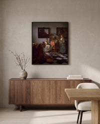 The Concert by Johannes Vermeer in a black frame above a walnut sideboard in a dining room