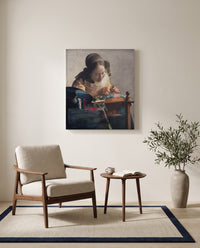 The Lacemaker by Johannes Vermeer as a stretched canvas above a linen lounge chair in a reading corner