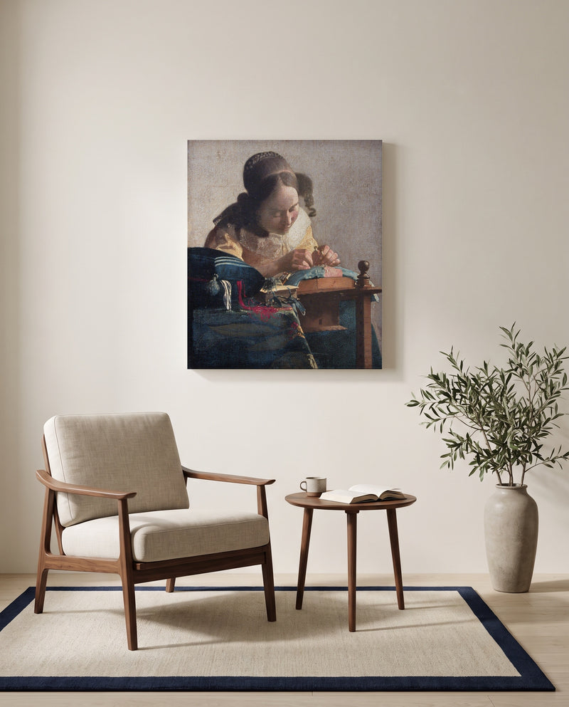 The Lacemaker by Johannes Vermeer as a stretched canvas above a linen lounge chair in a reading corner