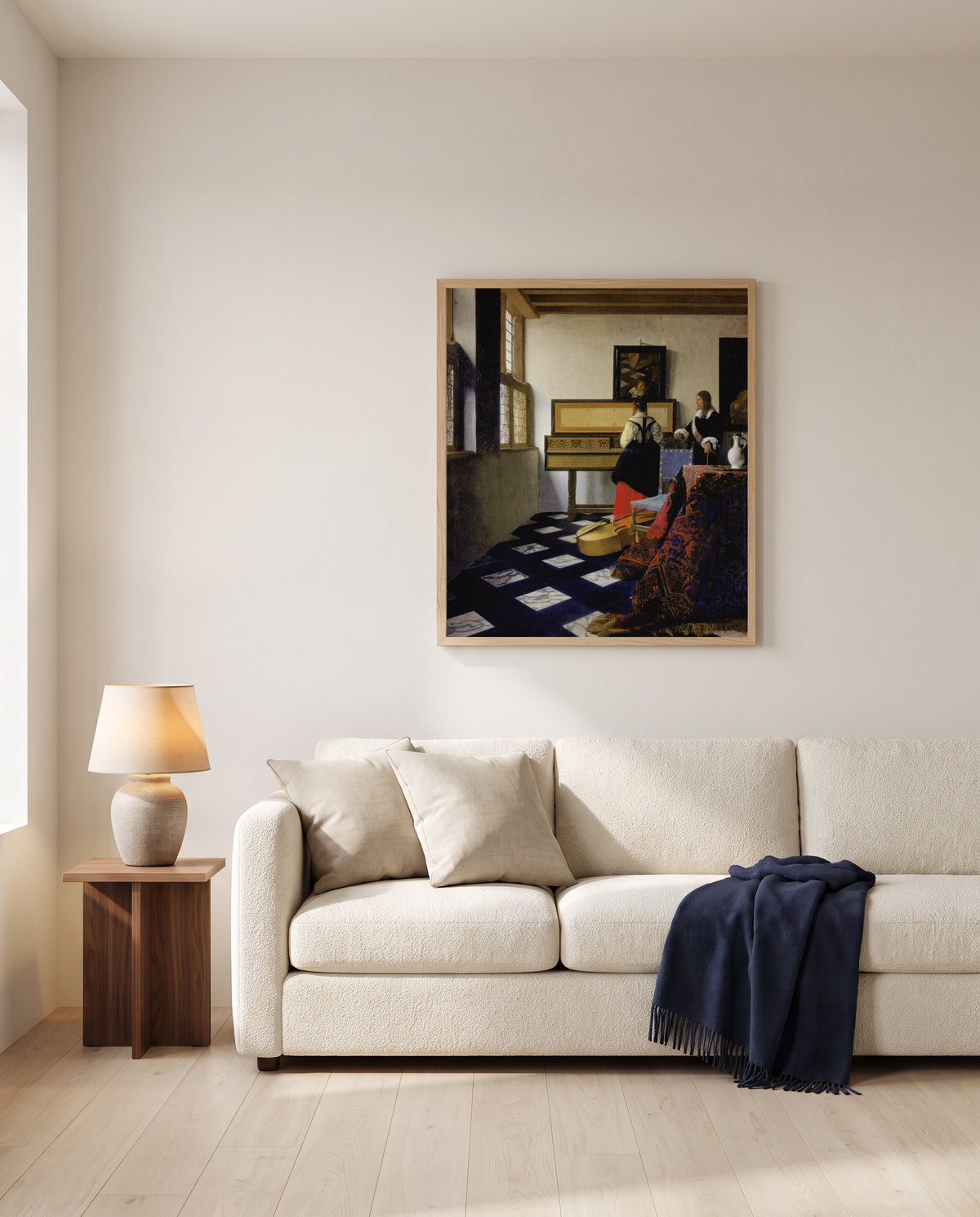 The Music Lesson by Johannes Vermeer framed in natural oak above a cream sofa in a warm living room