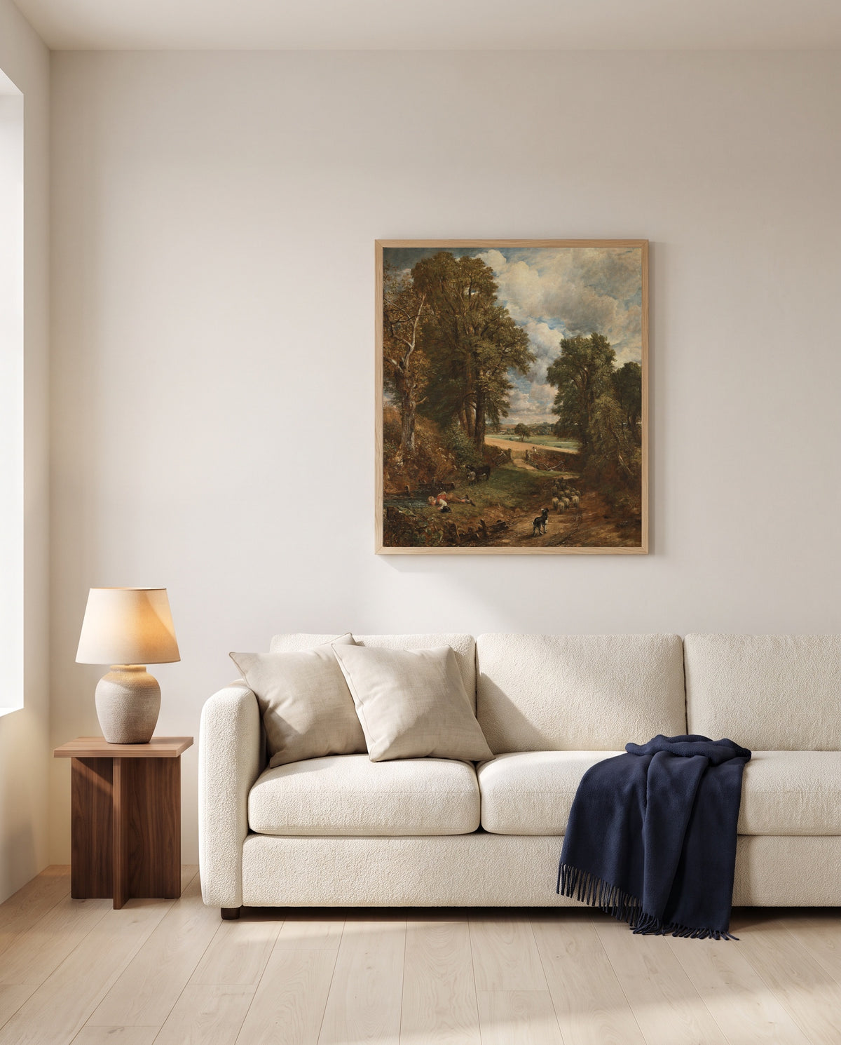 The Cornfield by John Constable framed in natural oak above a cream sofa in a warm living room
