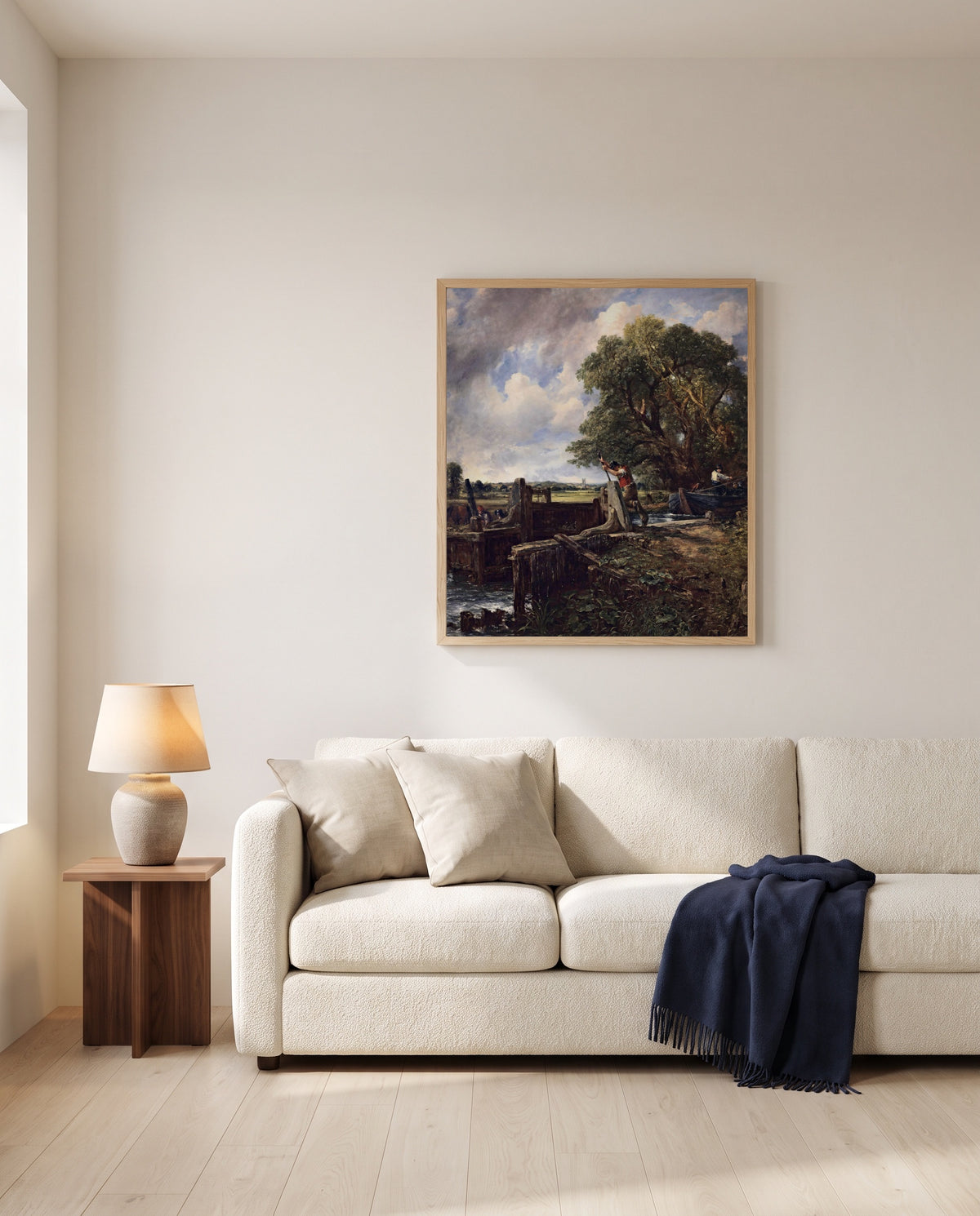 The Lock by John Constable framed in natural oak above a cream sofa in a warm living room