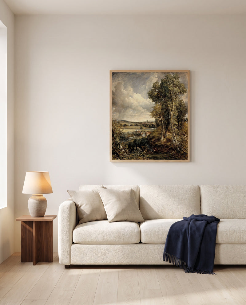 The Vale of Dedham by John Constable framed in natural oak above a cream sofa in a warm living room