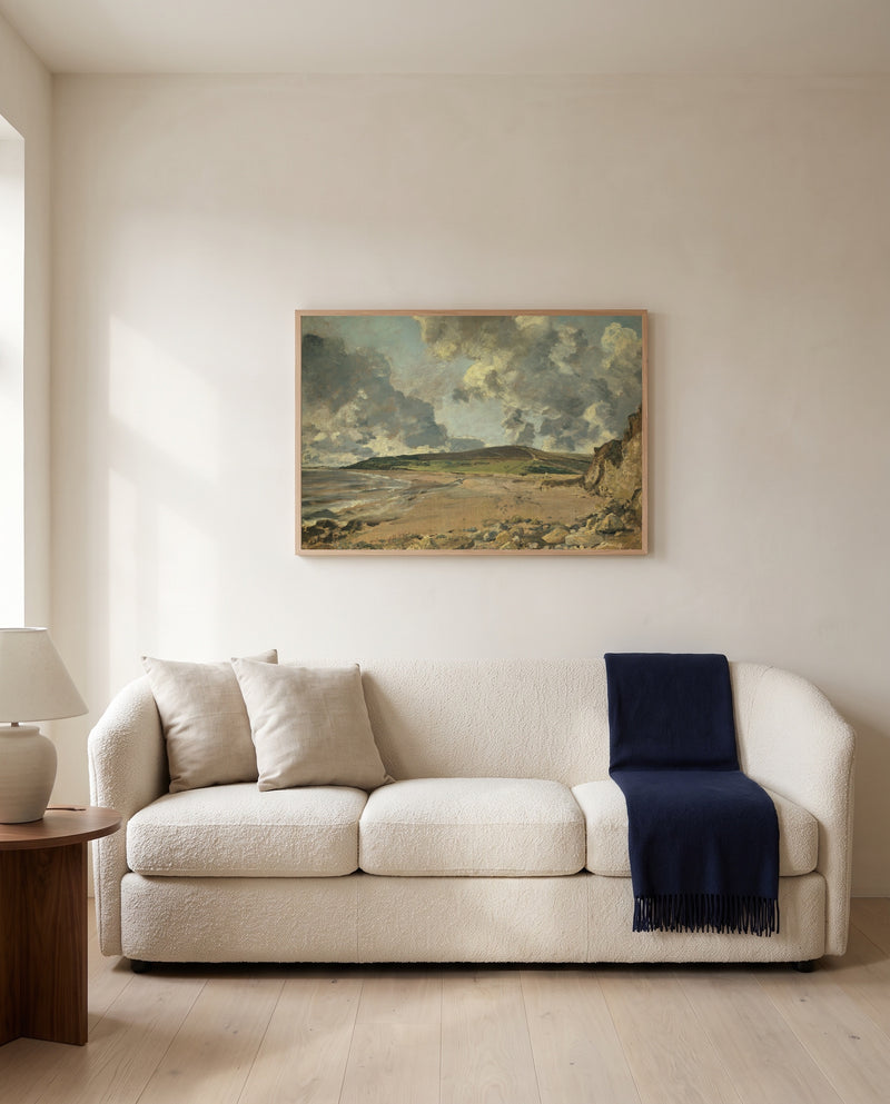 Weymouth Bay by John Constable framed in natural oak above a cream sofa in a warm living room
