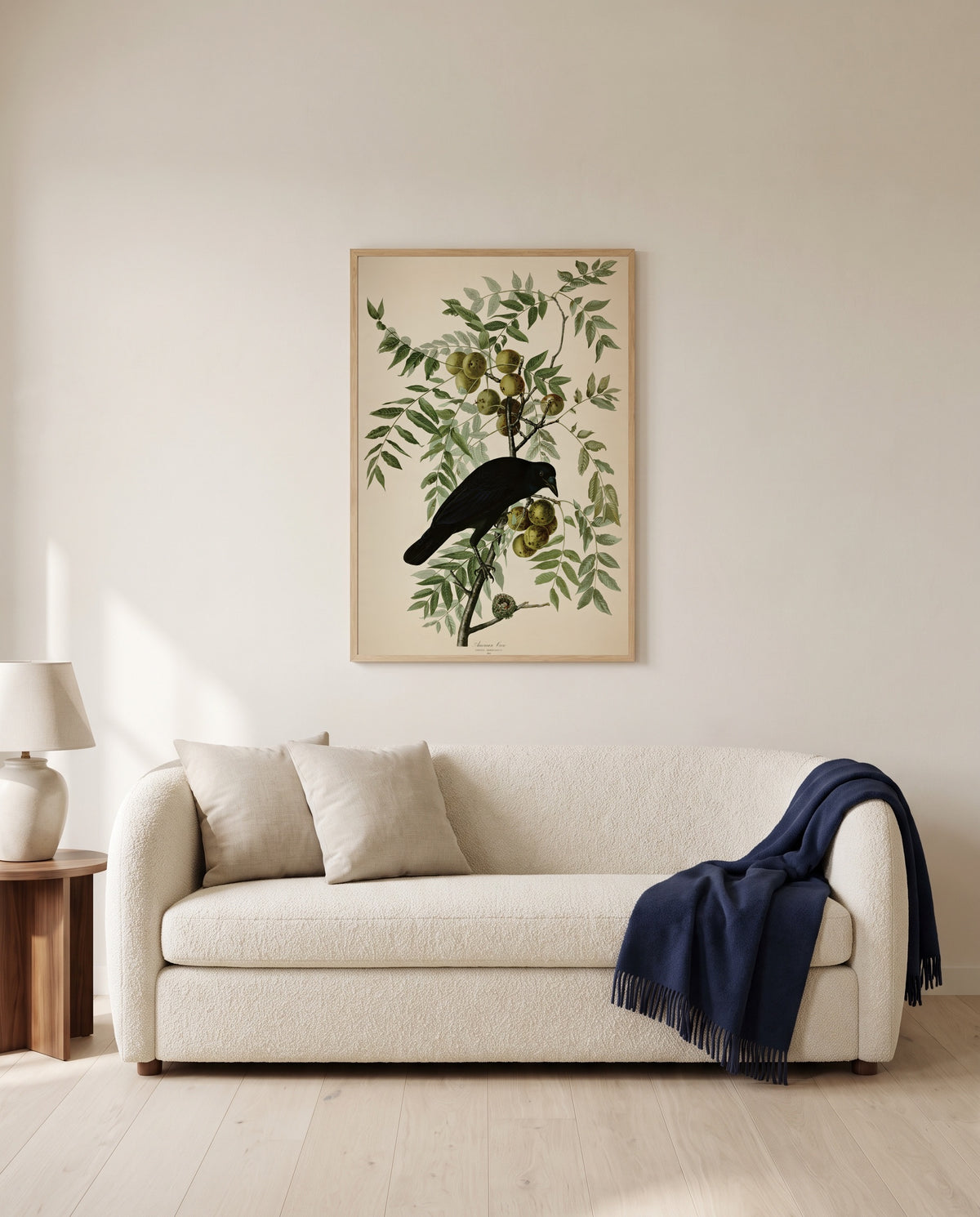 American Crow by John James Audubon framed in natural oak above a cream sofa in a warm living room