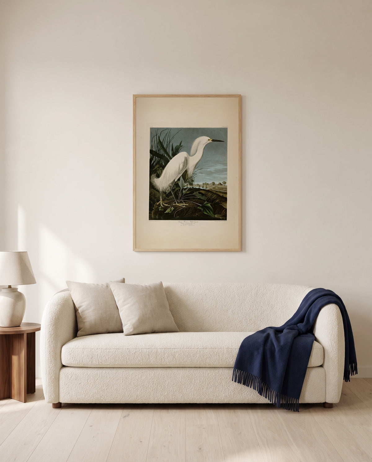 Snowy Heron by John James Audubon framed in natural oak above a cream sofa in a warm living room