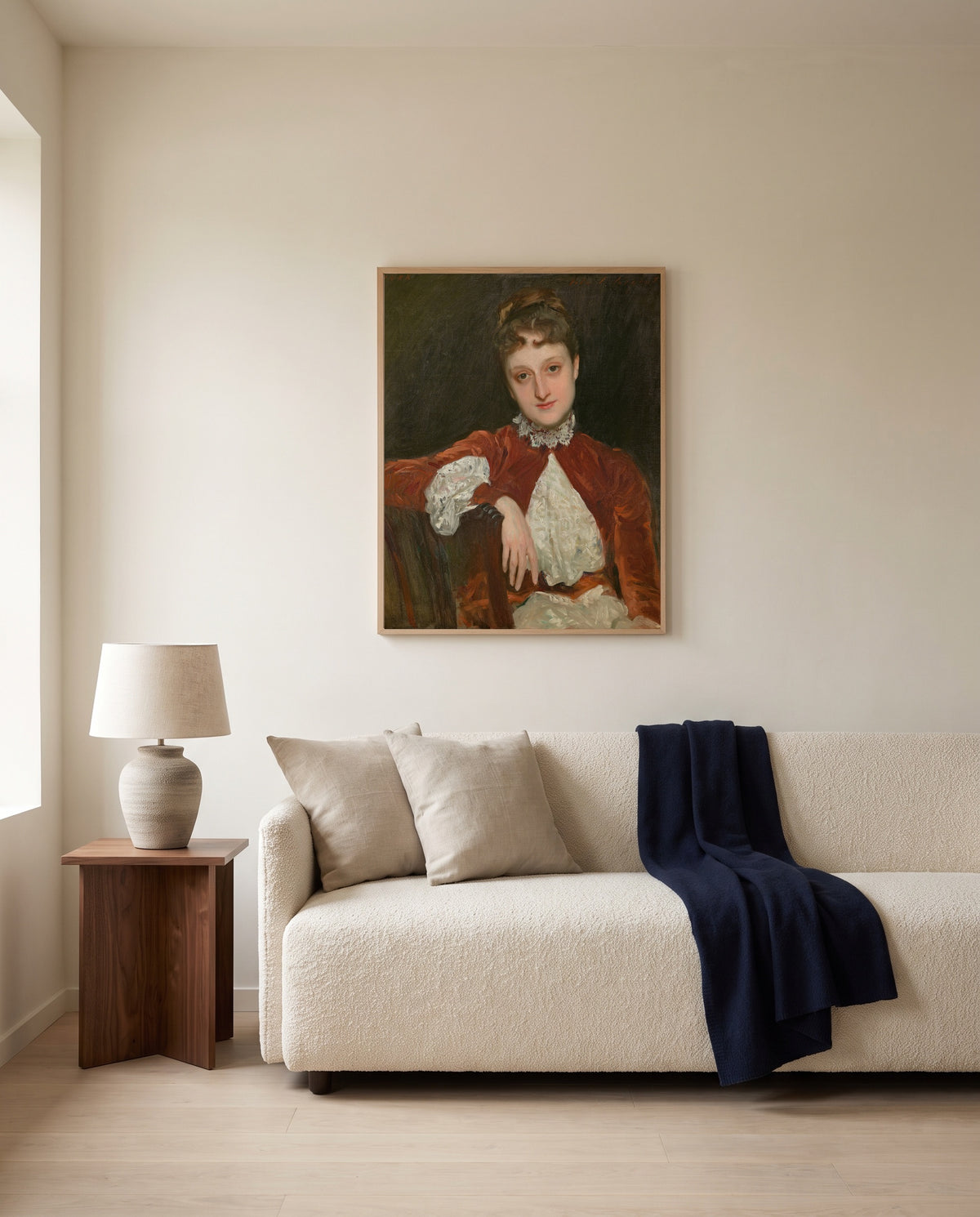 Mrs. Charles Deering by John Singer Sargent framed in natural oak above a cream sofa in a warm living room