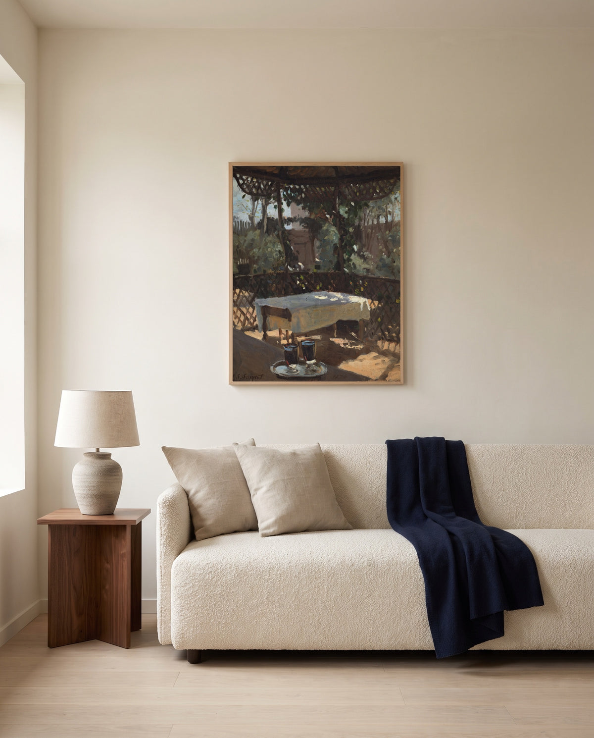 Wineglasses by John Singer Sargent framed in natural oak above a cream sofa in a warm living room