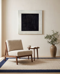Black Square by Kazimir Malevich as a stretched canvas above a linen lounge chair in a reading corner