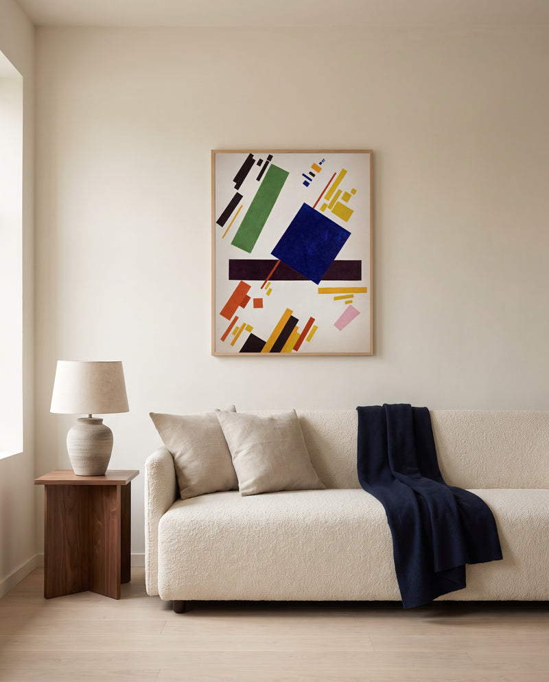 Suprematist Composition by Kazimir Malevich framed in natural oak above a cream sofa in a warm living room