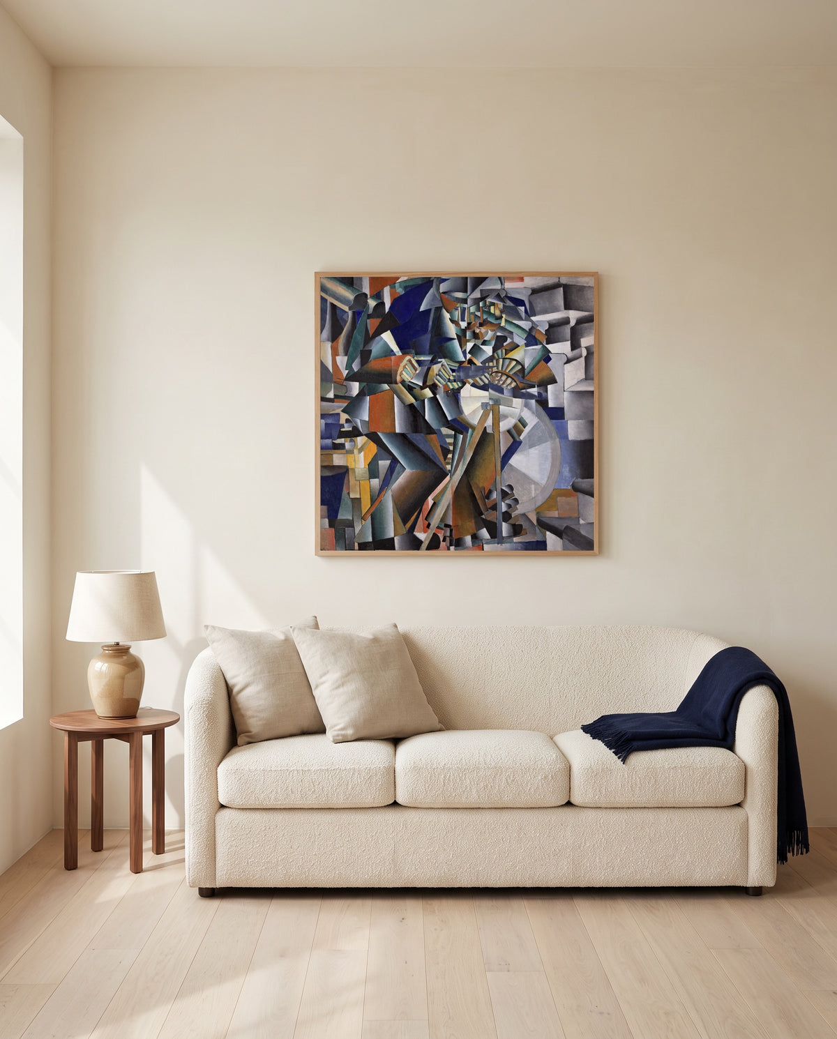The Knife Grinder by Kazimir Malevich framed in natural oak above a cream sofa in a warm living room