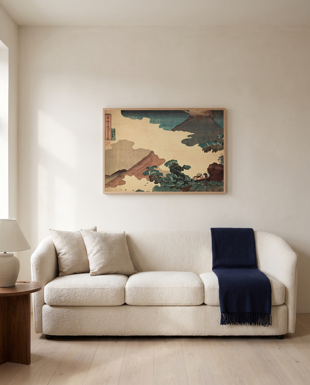 Mount Asama from Usui Pass by Utagawa Kuniyoshi framed in natural oak above a cream sofa in a warm living room