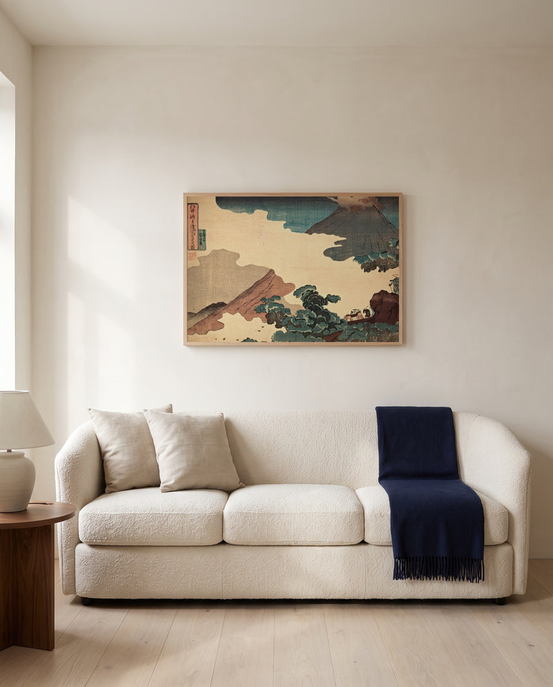 Mount Asama from Usui Pass by Utagawa Kuniyoshi framed in natural oak above a cream sofa in a warm living room