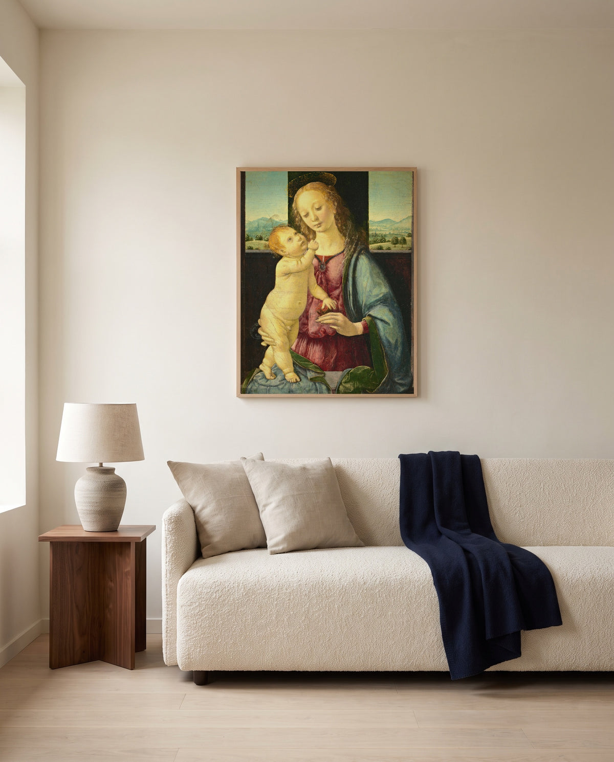 Madonna with a Pomegranate by Lorenzo di Credi framed in natural oak above a cream sofa in a warm living room