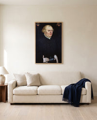 Portrait of Johann Feige by Lucas Cranach the Elder framed in natural oak above a cream sofa in a warm living room
