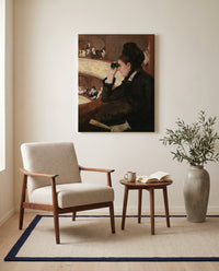 In the Loge by Mary Cassatt as a stretched canvas above a linen lounge chair in a reading corner