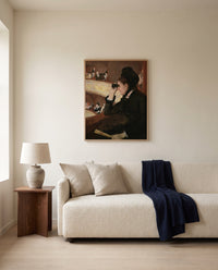In the Loge by Mary Cassatt framed in natural oak above a cream sofa in a warm living room