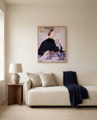 Lady at the Tea Table by Mary Cassatt framed in natural oak above a cream sofa in a warm living room
