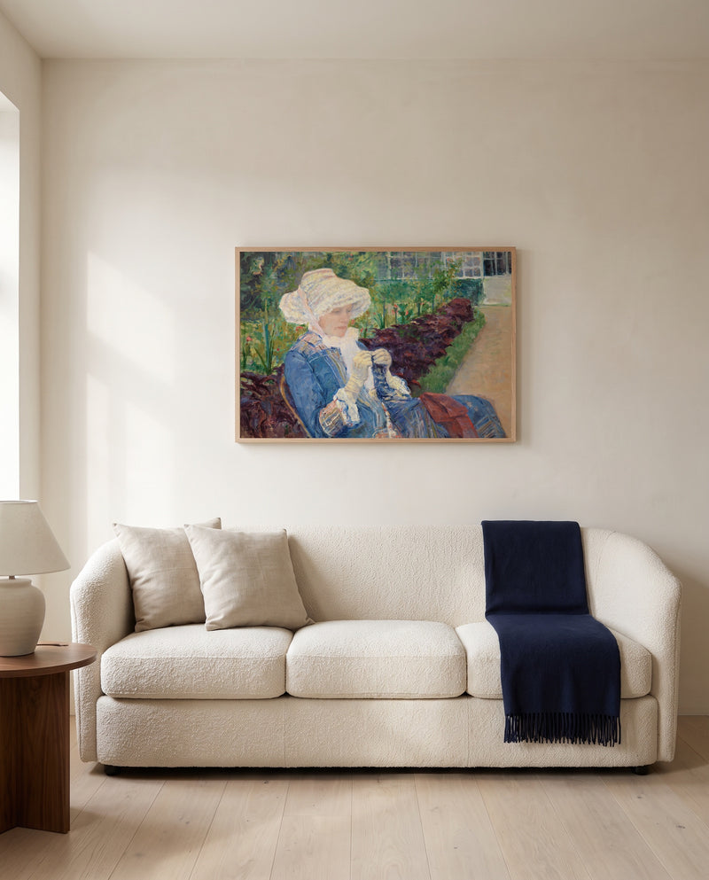Lydia Crocheting by Mary Cassatt framed in natural oak above a cream sofa in a warm living room