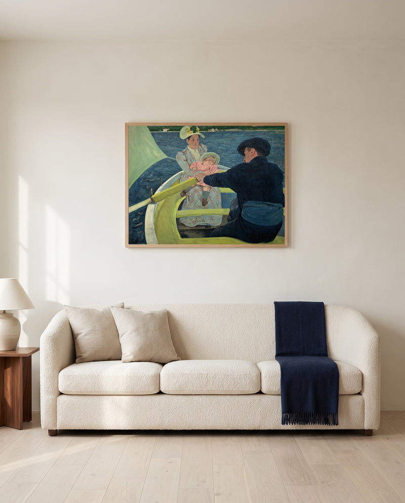 The Boating Party by Mary Cassatt framed in natural oak above a cream sofa in a warm living room