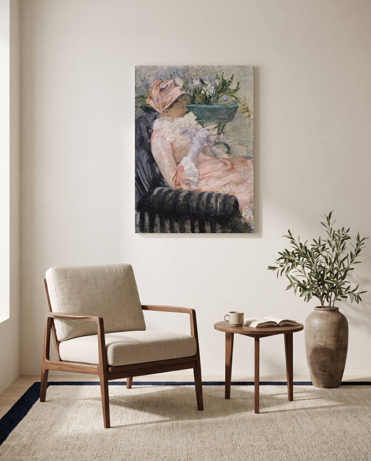 The Cup of Tea by Mary Cassatt as a stretched canvas above a linen lounge chair in a reading corner