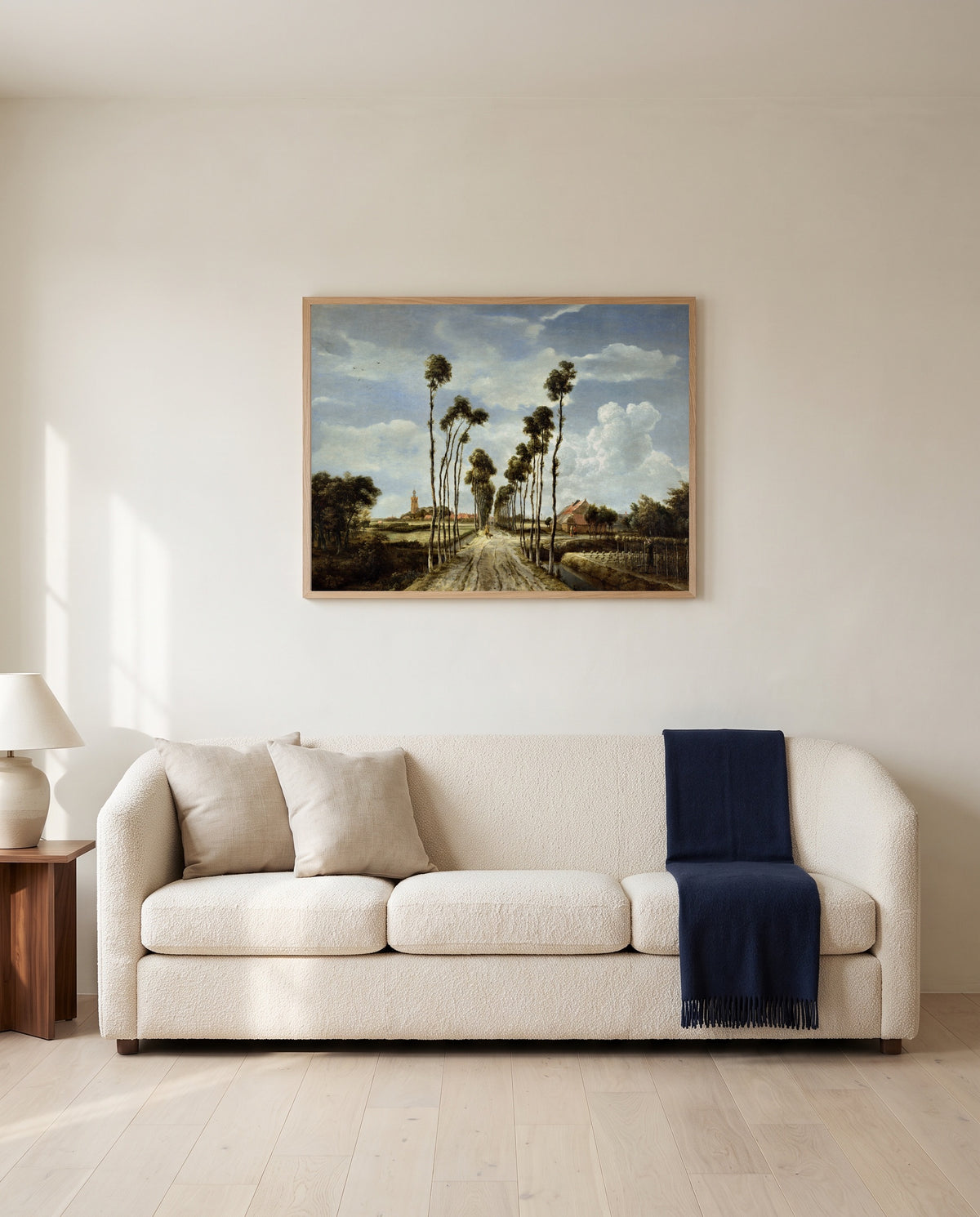 The Avenue at Middelharnis by Meindert Hobbema framed in natural oak above a cream sofa in a warm living room