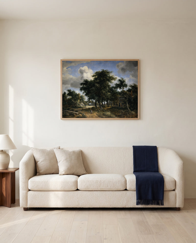 Village Street under Trees by Meindert Hobbema framed in natural oak above a cream sofa in a warm living room