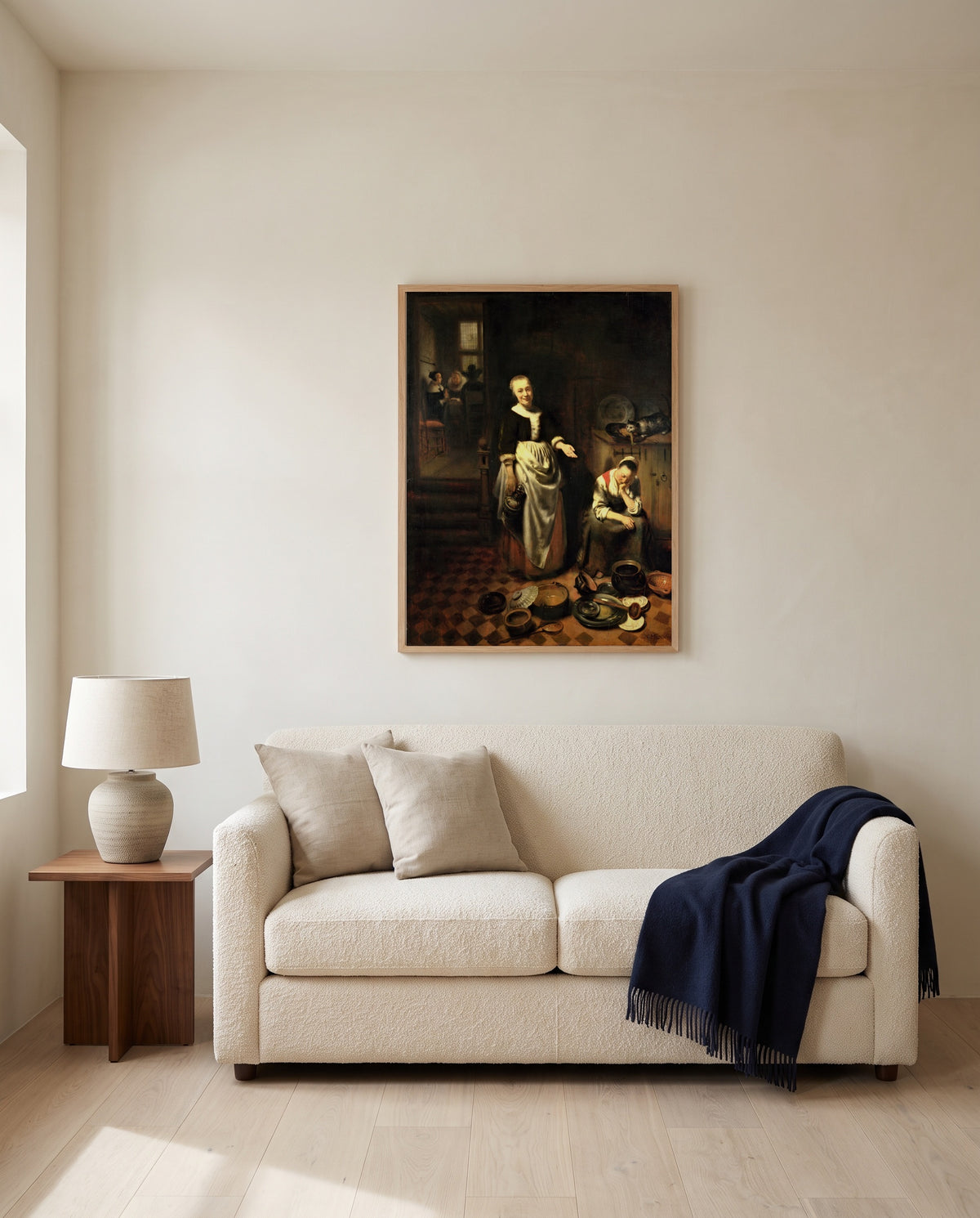 The Idle Servant by Nicolaes Maes framed in natural oak above a cream sofa in a warm living room