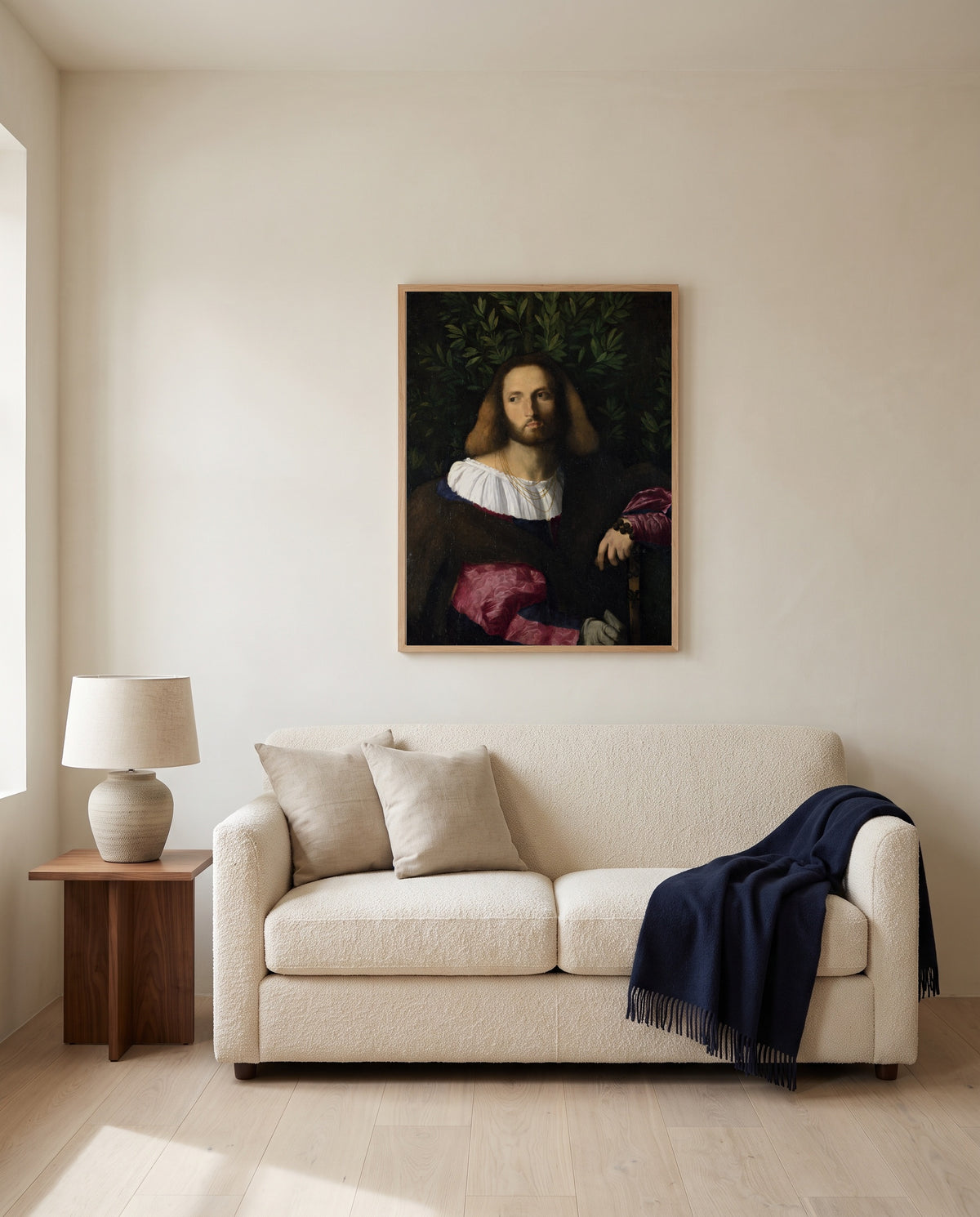 Portrait of a Poet by Palma Vecchio framed in natural oak above a cream sofa in a warm living room