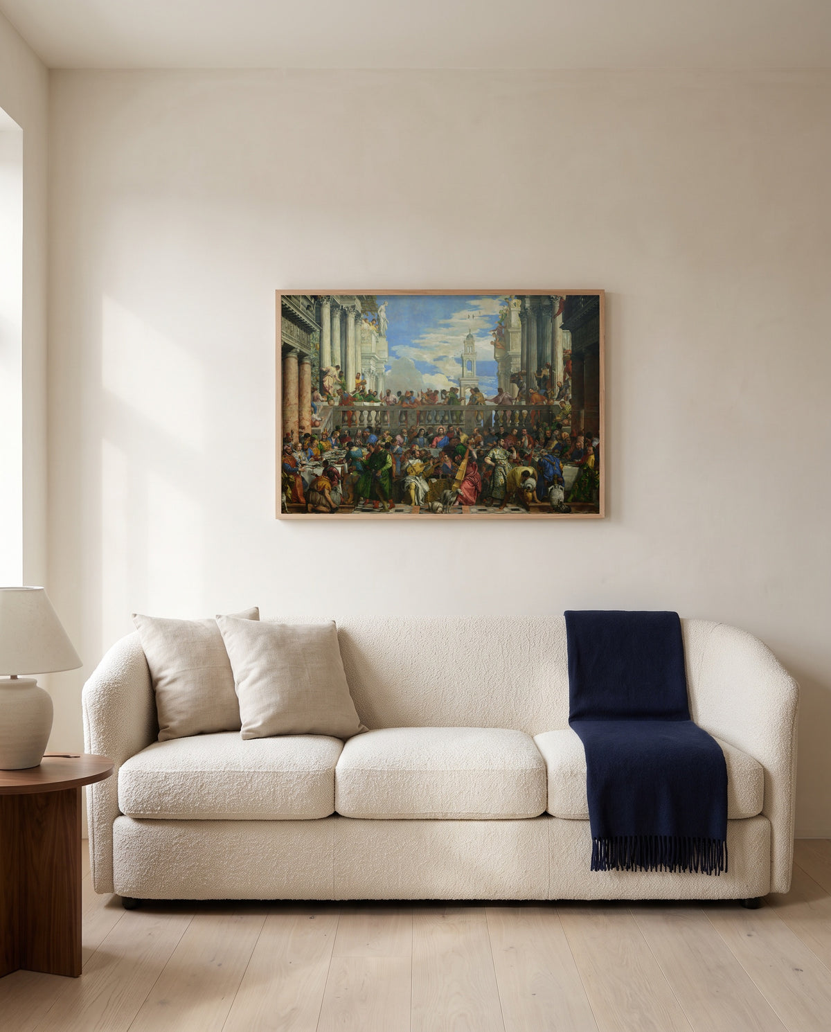 The Wedding at Cana by Paolo Veronese framed in natural oak above a cream sofa in a warm living room