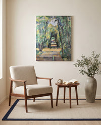 Avenue at Chantilly by Paul Cézanne as a stretched canvas above a linen lounge chair in a reading corner